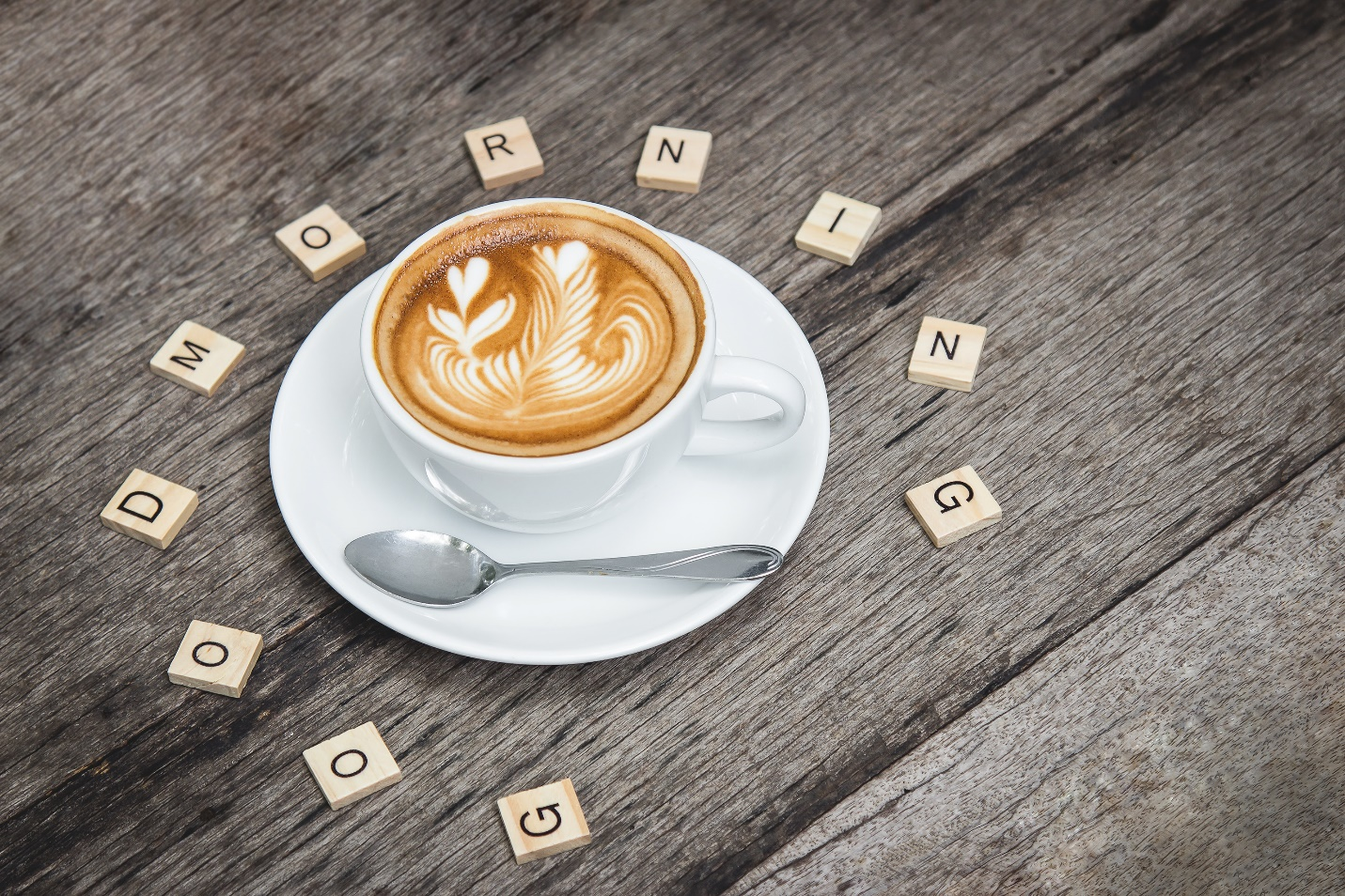 Good morning written with scrabble tiles around a cup of coffee